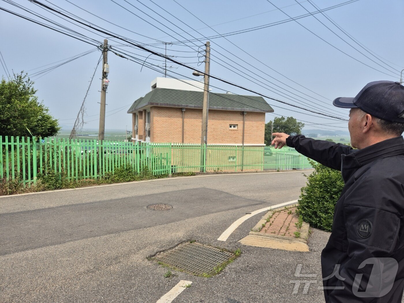 본문 이미지 - 강화군 교동도 주민 김진합 씨(68)가 울타리 너머 이북을 가리키고 있다. 2024.06.10.이시명기자/뉴스1