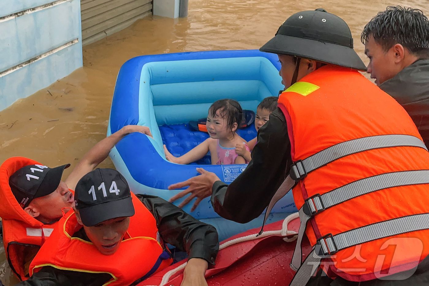 (하장 AFP=뉴스1) 우동명 기자 = 10일 (현지시간) 폭우가 쏟아진 베트남 북부 하장의 물에 잠긴 도로에서 구조대원이 고무 보트의 어린이를 구조하고 있다. 2024.06.11 …