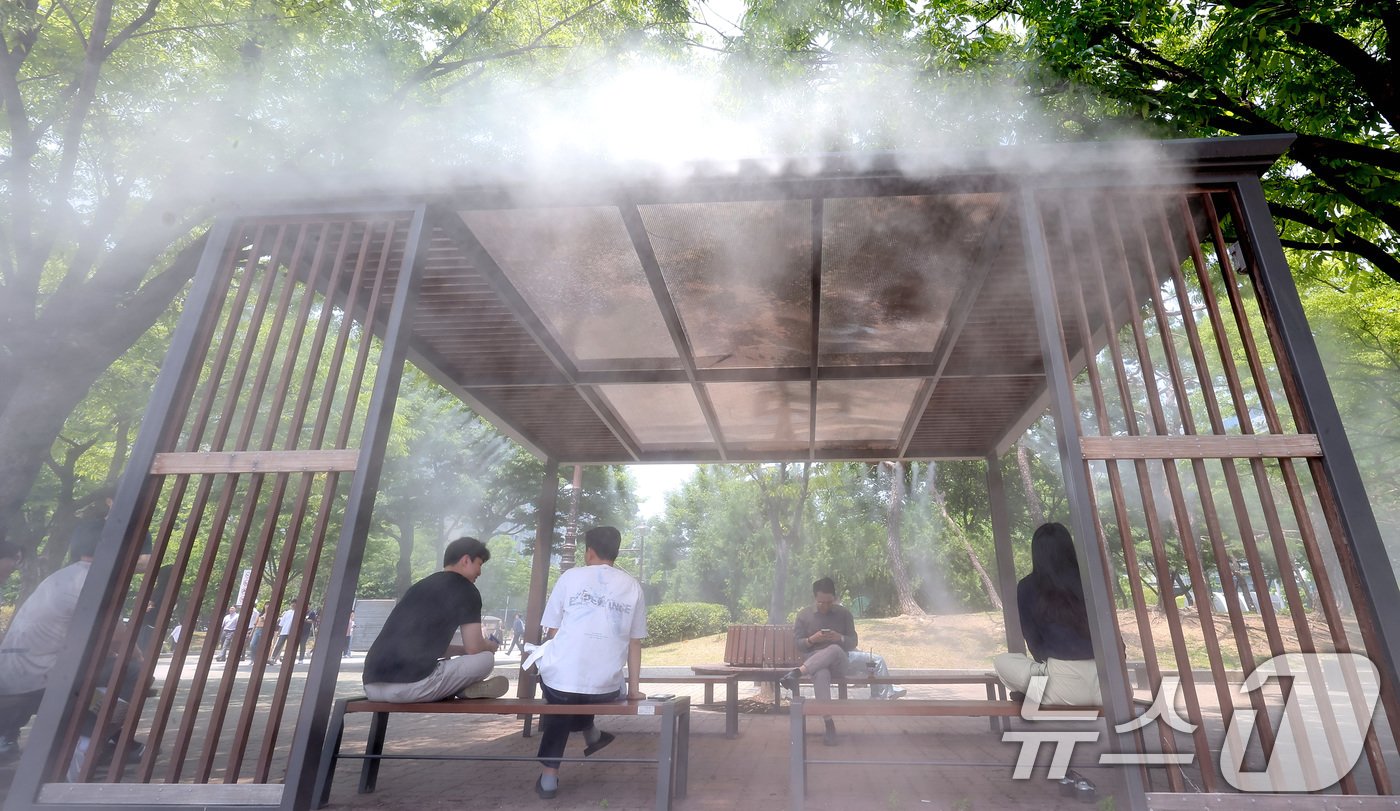 본문 이미지 - 전국 대부분 지역에서 체감온도가 최고 31도 이상 오르며 무더운 날씨를 보인 11일 서울 영등포구 여의도공원에서 시민들이 쿨링포그 아래 휴식을 취하고 있다. 2024.6.11/뉴스1 ⓒ News1 김성진 기자