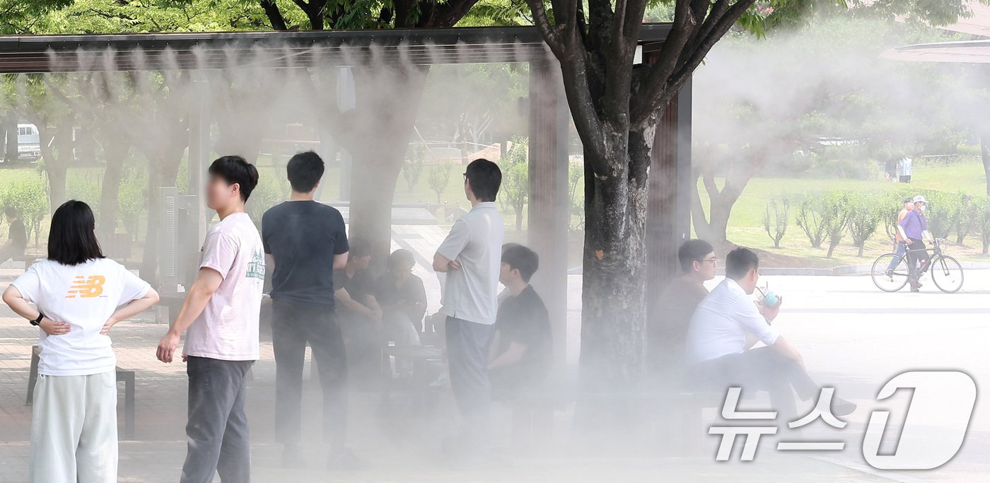 본문 이미지 - 전국 대부분 지역에서 체감온도가 최고 31도 이상 오르며 무더운 날씨를 보인 11일 서울 영등포구 여의도공원에서 시민들이 쿨링포그 아래 휴식을 취하고 있다. 2024.6.11/뉴스1 ⓒ News1 김성진 기자