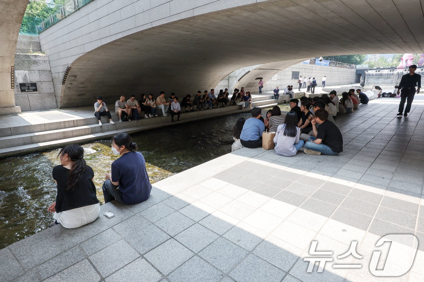 본문 이미지 - 서울 지역 낮 최고 기온이 32도까지 올라 무더위가 찾아온 11일 서울 종로구 청계천 산책로를 찾은 시민들이 그늘 아래 모여 햇빛을 피하고 있다. 2024.6.11/뉴스1 ⓒ News1 민경석 기자