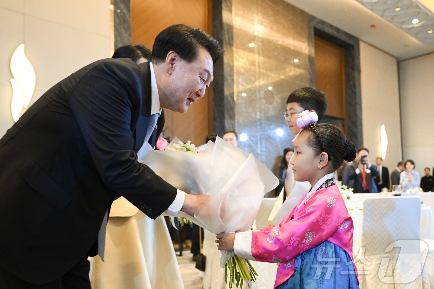 본문 이미지 - 윤석열 대통령이 11일(현지시간) 카자흐스탄 아스타나의 한 호텔에서 열린 고려인 동포·재외국민 초청 간담회에 참석해 화동으로부터 꽃다발을 받고 있다. (대통령실 제공) 2024.6.12/뉴스1 ⓒ News1 송원영 기자