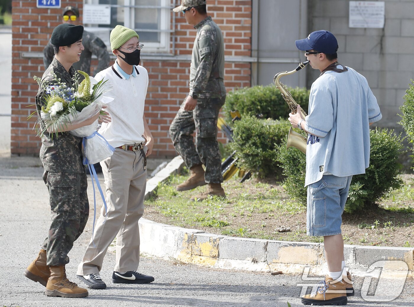 본문 이미지 - 그룹 방탄소년단(BTS) RM(오른쪽)이 12일 오전 경기도 연천 소재 육군 제5보병사단 신병교육대대에서 육군 현역으로 군 복무를 마친 진을 섹소폰 연주로 축하하고 있다. ⓒ News1 권현진 기자