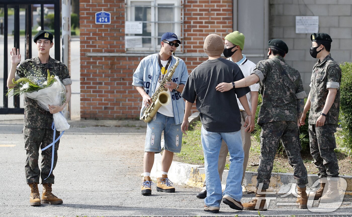 본문 이미지 - 그룹 방탄소년단(BTS) 진(왼쪽)이 12일 오전 경기도 연천 소재 육군 제5보병사단 신병교육대대에서 육군 현역으로 군 복무를 마친 뒤 인사를 하고 있다. 옆으로는 진의 전역을 축하하는 RM과 뷔, 제이홉, 정국, 지민이 그의 곁은 지키고 있다. ⓒ News1 권현진 기자