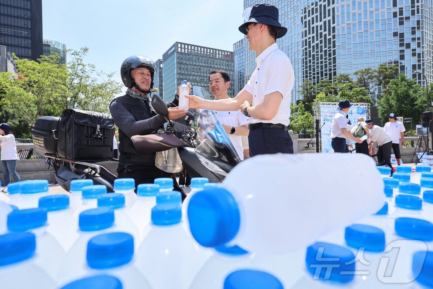 12일 오전 서울 중구 청계천 장통교에서 열린 2024년 이동노동자 생수나눔 공동사업단 주최 &#39;폭염대비 이동노동자 생수나눔 캠페인&#39;에서 한 이동노동자가 생수를 받고 있다.. 2024.6.12/뉴스1 ⓒ News1 김도우 기자