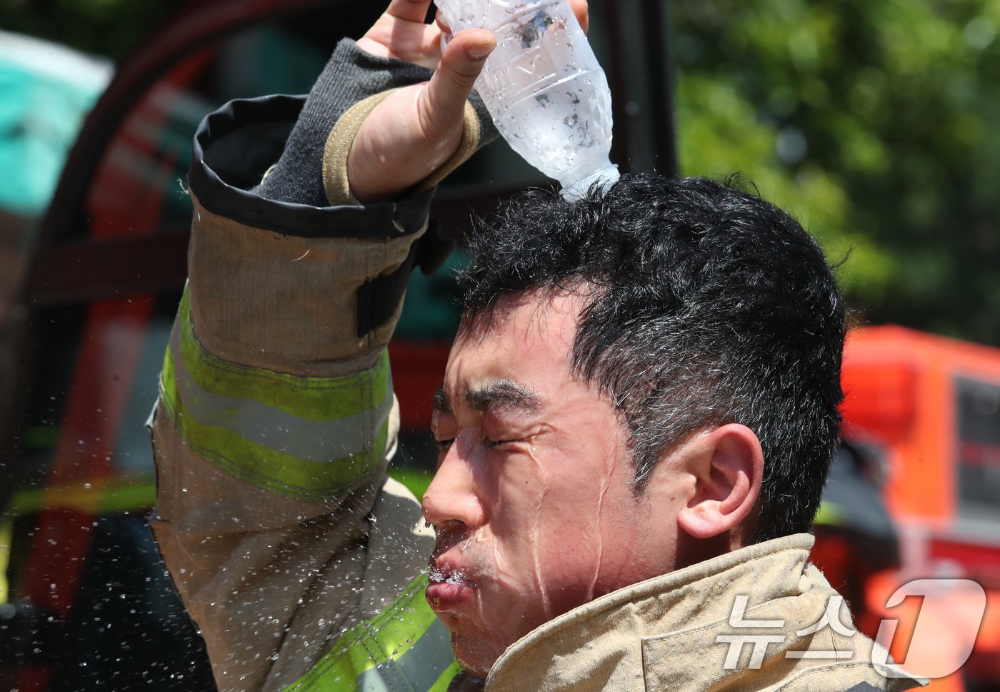 대전지역의 최고 온도가 33도 이상 오르는 등 무더운 날씨를 보인 12일 대전 동구 용운동에서 훈련을 마친 소방관이 물을 뿌리며 더위를 식히고 있다. 2024.6.12/뉴스1 ⓒ News1 김기태 기자