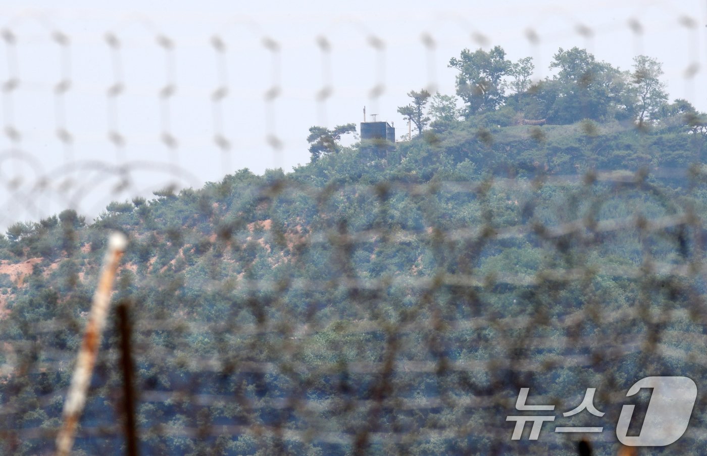 본문 이미지 - 북한의 오물풍선에 대응한 대북전단 살포,와 확성기 가동 등으로 남북간 긴장이 고조되는 가운데 12일 오후 인천 강화군 송해면 당산리에서 바라본 북한 황해도 개풍군 야산에 북한의 대남 확성기로 보이는 구조물이 설치되어 있다. 2024.6.12/뉴스1 ⓒ News1 오대일 기자