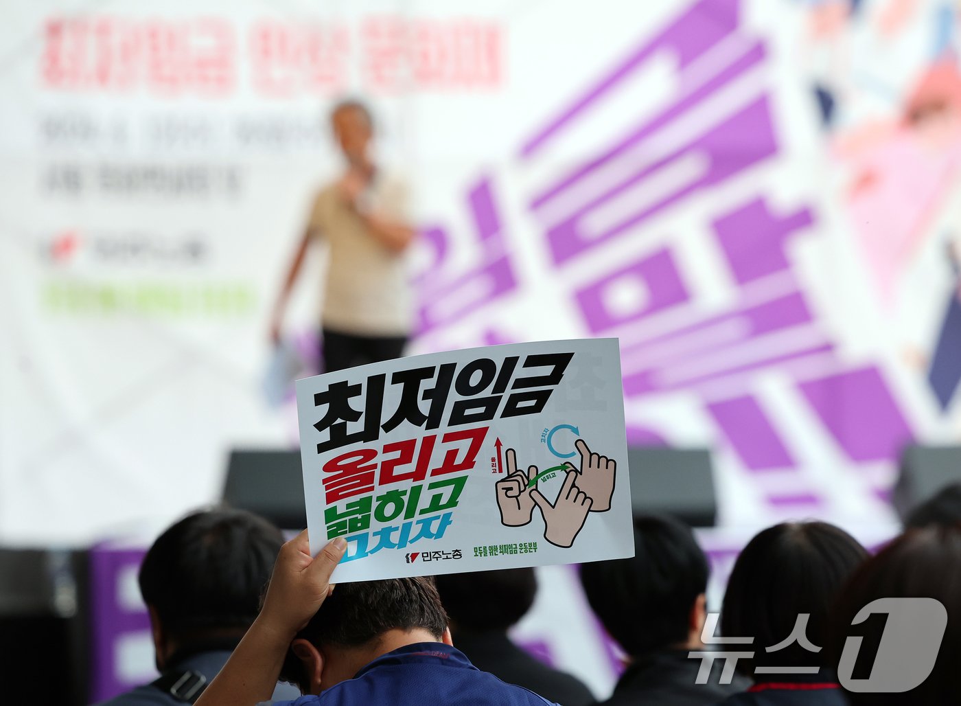 본문 이미지 - 민주노총 조합원들이 12일 오후 서울 중구 동화면세점 앞에서 모두를 위한 최저임금 운동본부 주최로 열린 최저임금 문화제, '최저임금, 나도 할 말 있어요!!'에서 '최저임금 올리고 넓히고 고치자'가 적힌 피켓을 들고 있다. 2024.6.12/뉴스1 ⓒ News1 김진환 기자