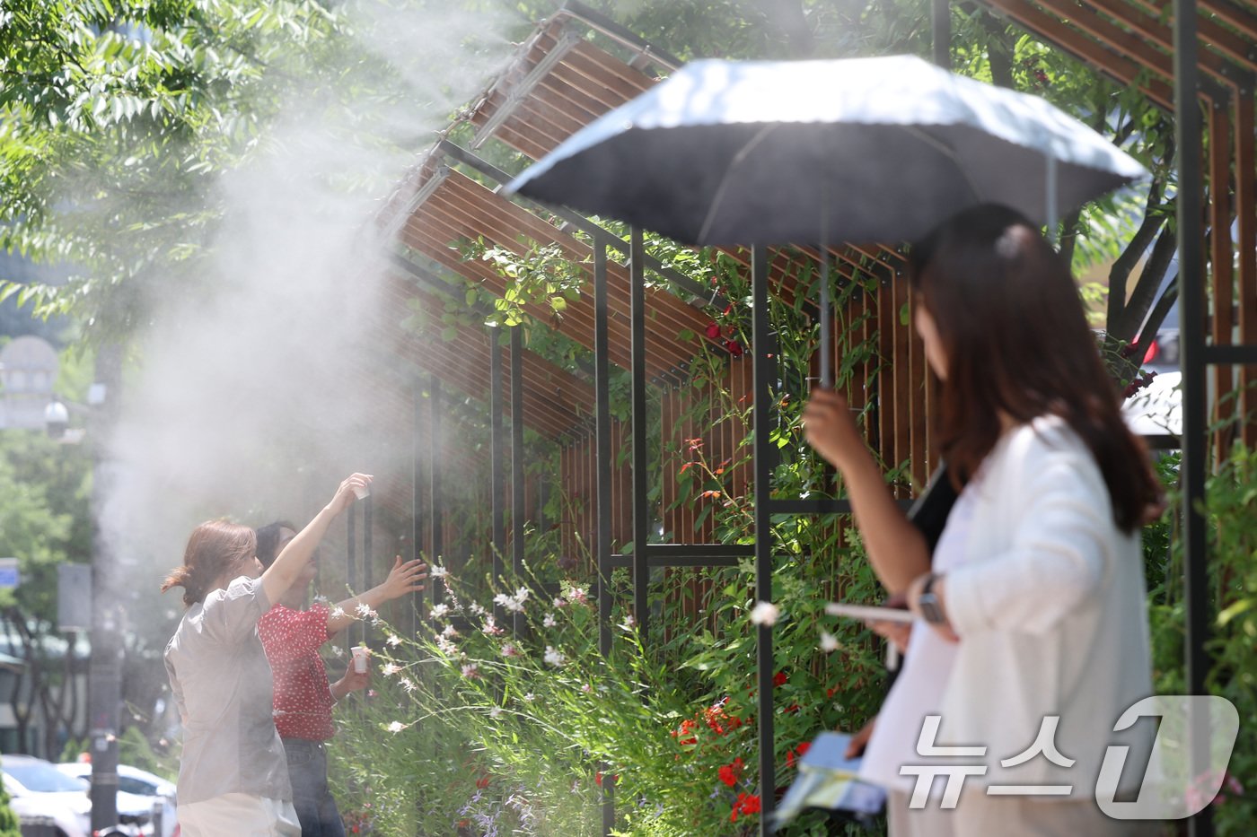 본문 이미지 - 13일 오후 서울시청 앞에서 시민들이 쿨링포그를 맞으며 더위를 식히고 있다. 이날 서울의 낮 기온 32도까지 올라가는 등 대부분 지역이 30도를 넘을 것으로 보인다. 기상청은 내일까지 때이른 더위가 이어지다가 토요일에 수도권과 강원 영서에 비가 내리며 더위가 주춤할 것으로 예보했다. 2024.6.13/뉴스1 ⓒ News1 신웅수 기자
