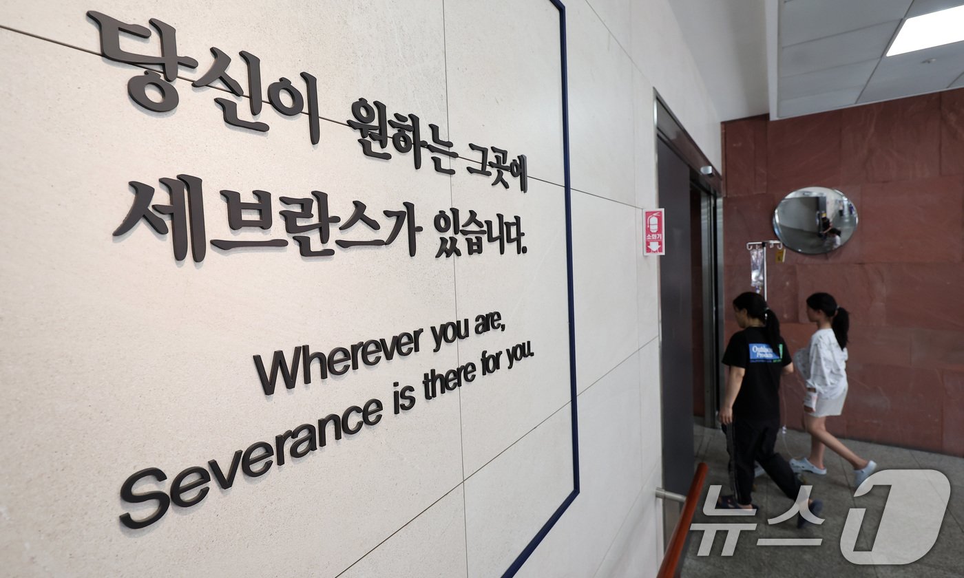 본문 이미지 - 연세의료원 산하 세브란스병원, 강남세브란스병원, 용인세브란스병원 세 곳에 소속된 교수들이 정부에 반발해 오는 27일부터 무기한 휴진을 예고한 가운데, 13일 서울 서대문구 신촌 세브란스병원 내 복도에 '당신이 원하는 그곳에 세브란스가 있습니다'라는 문구가 뒤로 환자가 걸어가고 있다. 2024.6.13/뉴스1 ⓒ News1 김성진 기자