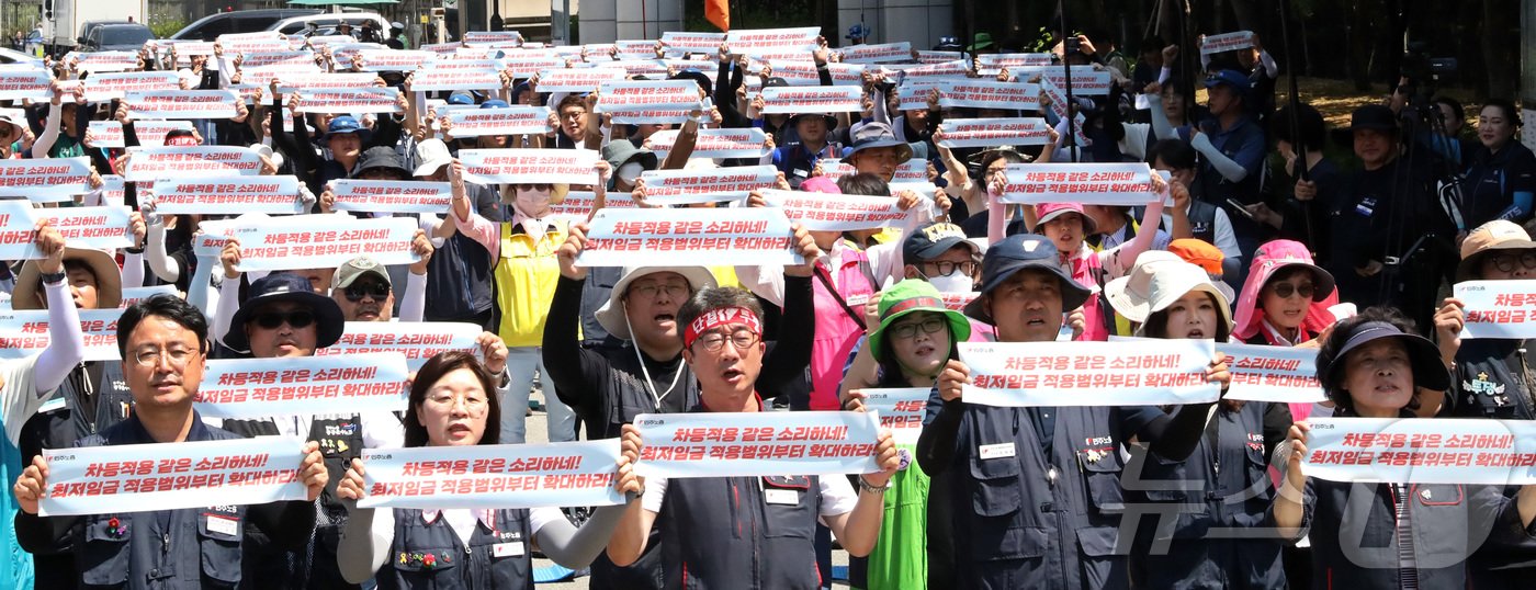 본문 이미지 - 13일 오후 최저임금위원회 제4차 전원회의가 열리는 정부세종청사 최저임금위원회 앞에서 열린 민주노총 최저임금 결의대회에 참여한 노조원들이 고용노동부 입간판에 최저임금의 대폭인상·차등적용 폐기·적용범위 확대 등을 요구하며 구호를 외치고 있다.2024.6.13/뉴스1 ⓒ News1 김기남 기자