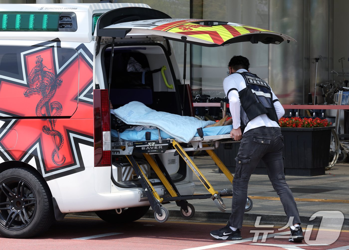 본문 이미지 - 정부의 의대 정원 증원에 반발해 전국 수련병원에 사직서를 제출한 전공의를 비롯해 의료계의 집단행동이 이어지고 있는 14일 서울 시내 한 대학병원에서 환자가 구급차에 오르고 있다. 2024.6.14/뉴스1 ⓒ News1 박정호 기자