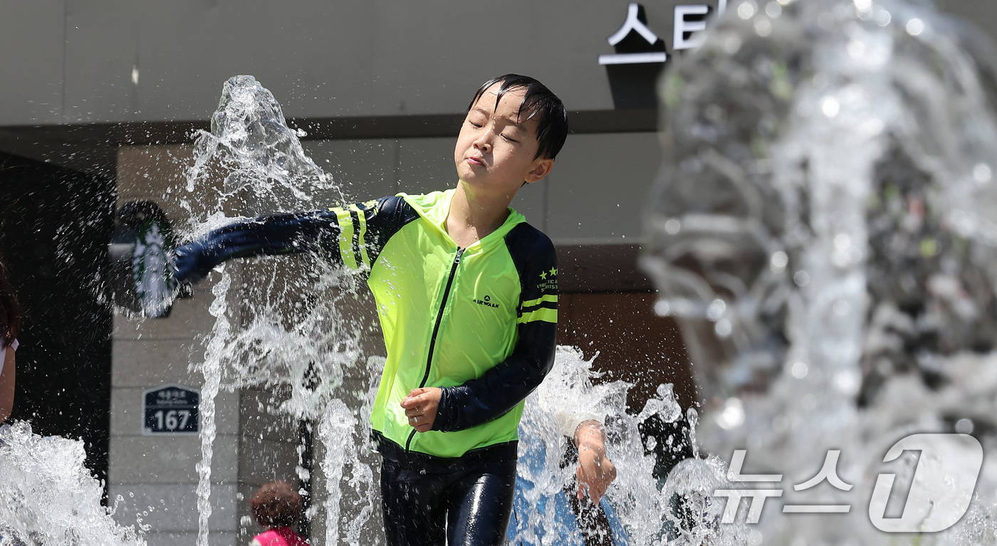 (서울=뉴스1) 김성진 기자 = 서울 낮 최고 기온이 30도 가까이 오르며 무더운 날씨를 보인 16일 서울 종로구 광화문광장 분수대에서 어린이들이 물놀이를 하며 무더위를 식히고 있 …