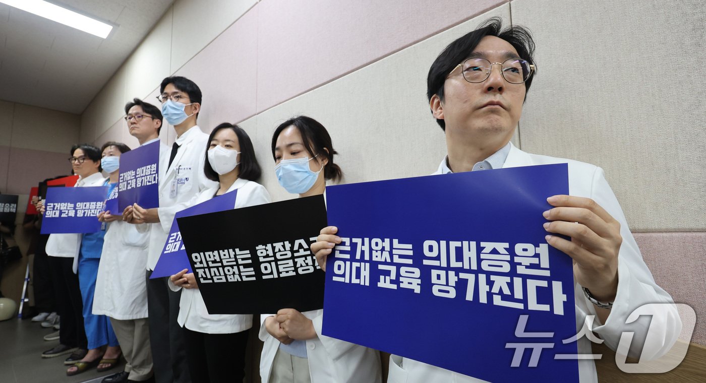 본문 이미지 - 서울대학교 의과대학 교수, 전공의, 의대생들이 17일 오전 서울 종로구 서울대학교 의과대학 융합관 양윤선홀에서 열린 휴진 결의 집회에서 손팻말을 들고 있다. .2024.6.17/뉴스1 ⓒ News1 박지혜 기자