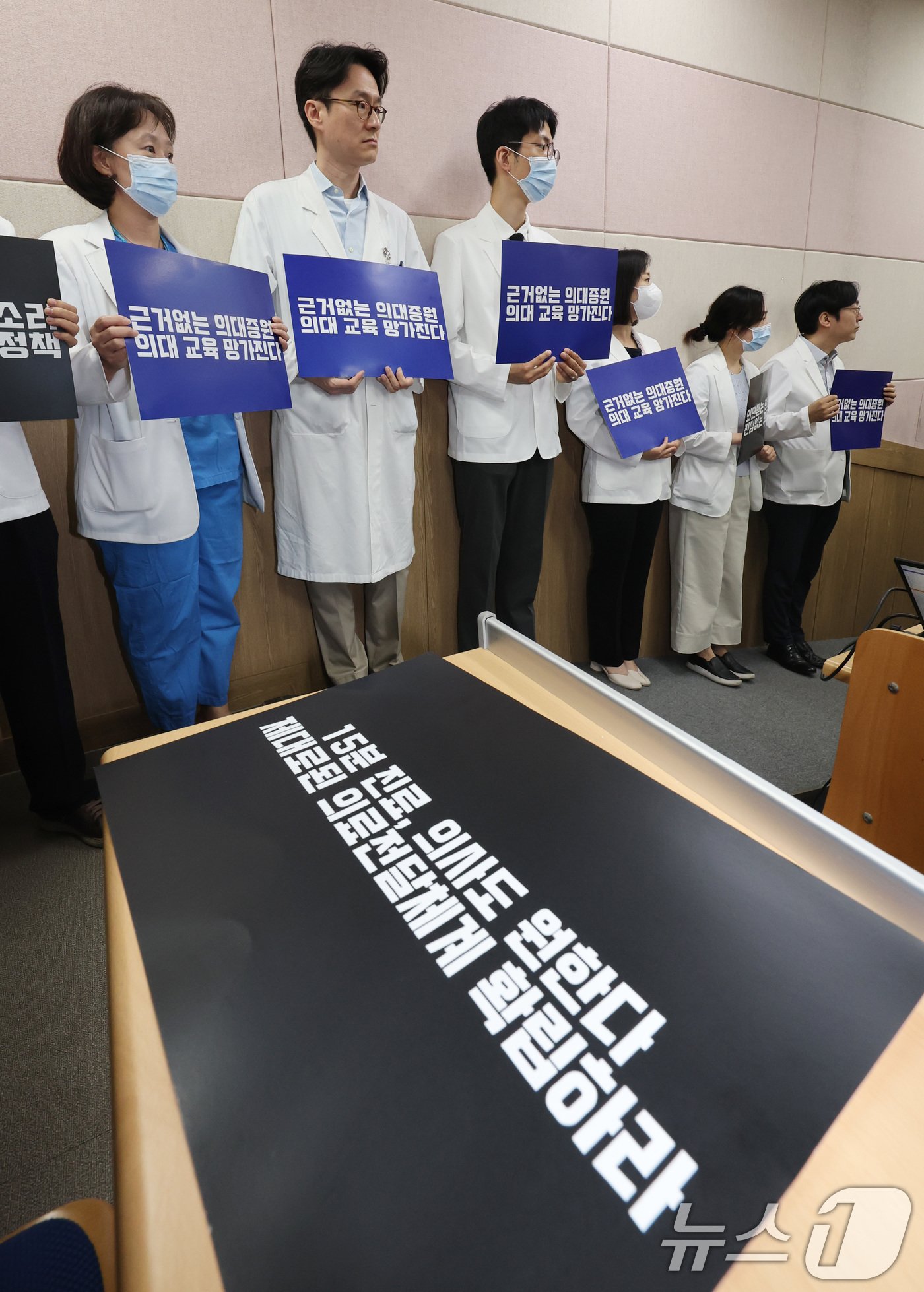 본문 이미지 - 서울대학교 의과대학 교수, 전공의, 의대생들이 17일 오전 서울 종로구 서울대학교 의과대학 융합관 양윤선홀에서 열린 휴진 결의 집회에서 손팻말을 들고 있다..2024.6.17/뉴스1 ⓒ News1 박지혜 기자