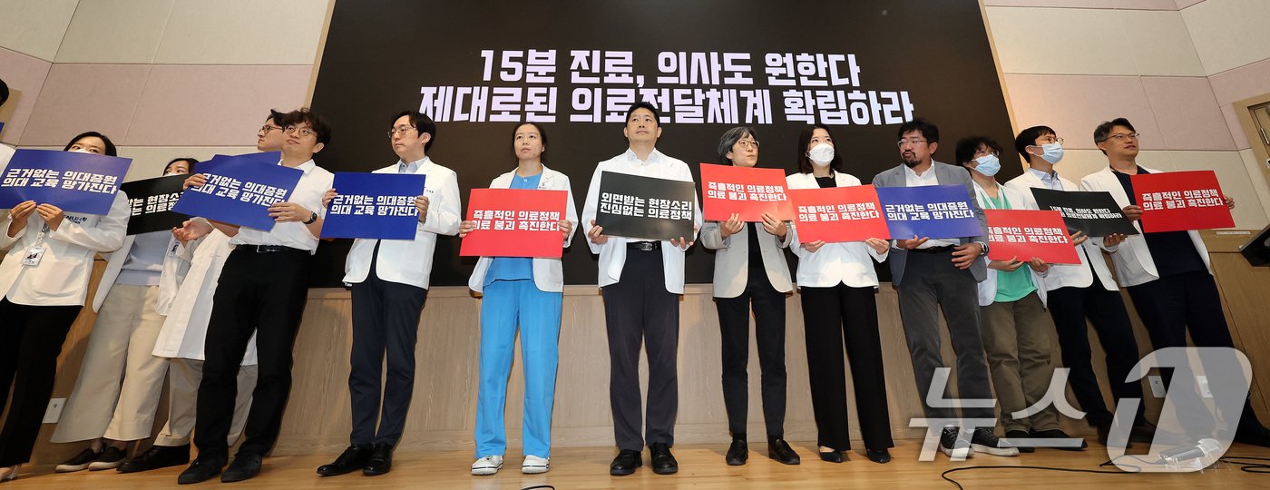 본문 이미지 - 서울대학교 의과대학 교수, 전공의, 의대생들이 17일 오전 서울 종로구 서울대학교 의과대학 융합관 양윤선홀에서 열린 휴진 결의 집회에서 손팻말을 들고 있다. .2024.6.17/뉴스1 ⓒ News1 박지혜 기자