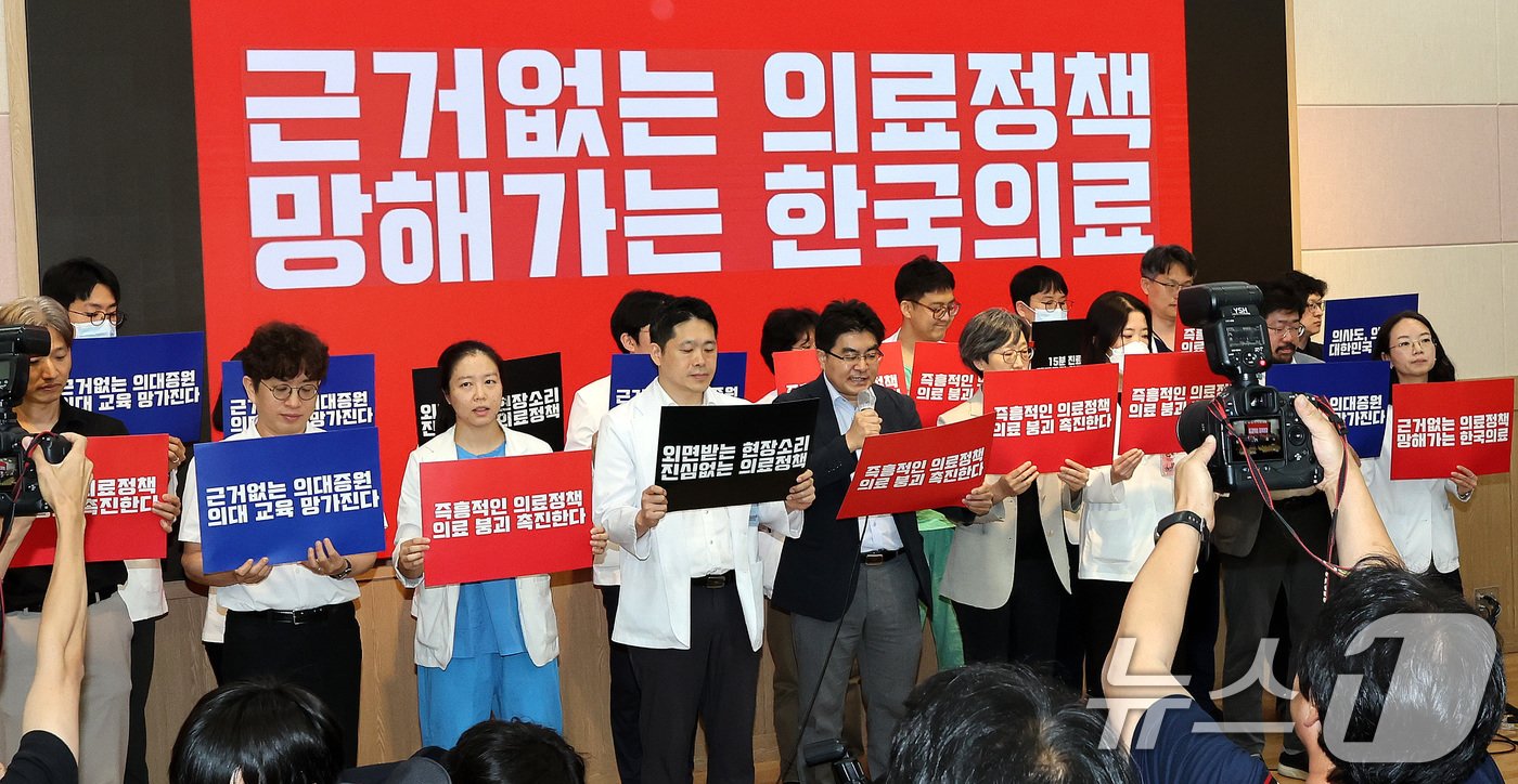 본문 이미지 - 서울대학교 의과대학 교수, 전공의, 의대생들이 17일 오전 서울 종로구 서울대학교 의과대학 융합관 양윤선홀에서 열린 휴진 결의 집회에서 손팻말을 들고 있다. 2024.6.17/뉴스1 ⓒ News1 박지혜 기자