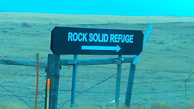 본문 이미지 - 넓은 목초지에 세워진 학교를 안내하는 이정표 2024.06.16/ &lt;출처Rock Solid Refuge 홈페이지&gt;