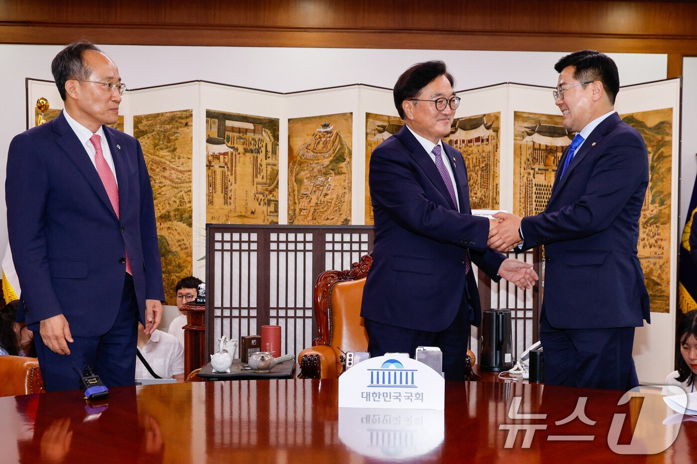 본문 이미지 - 우원식 국회의장과 박찬대 더불어민주당 원내대표가 17일 오후 서울 여의도 국회에서 원구성 논의 등을 위해 회동 전 악수를 하고 있다. 왼쪽은 추경호 국민의힘 원내대표. 2024.6.17/뉴스1 ⓒ News1 안은나 기자