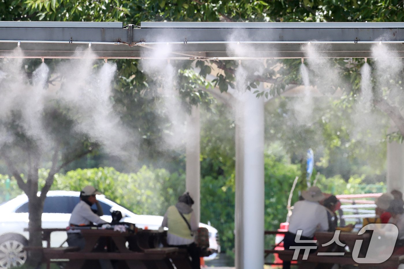 본문 이미지 - 폭염이 기승을 부린 18일 오후 대구 수성구 수성패밀리파크를 찾은 시민들이 쿨링포그가 가동된 그늘 쉼터에서 더위를 피하고 있다. 2024.6.18/뉴스1 ⓒ News1 공정식 기자