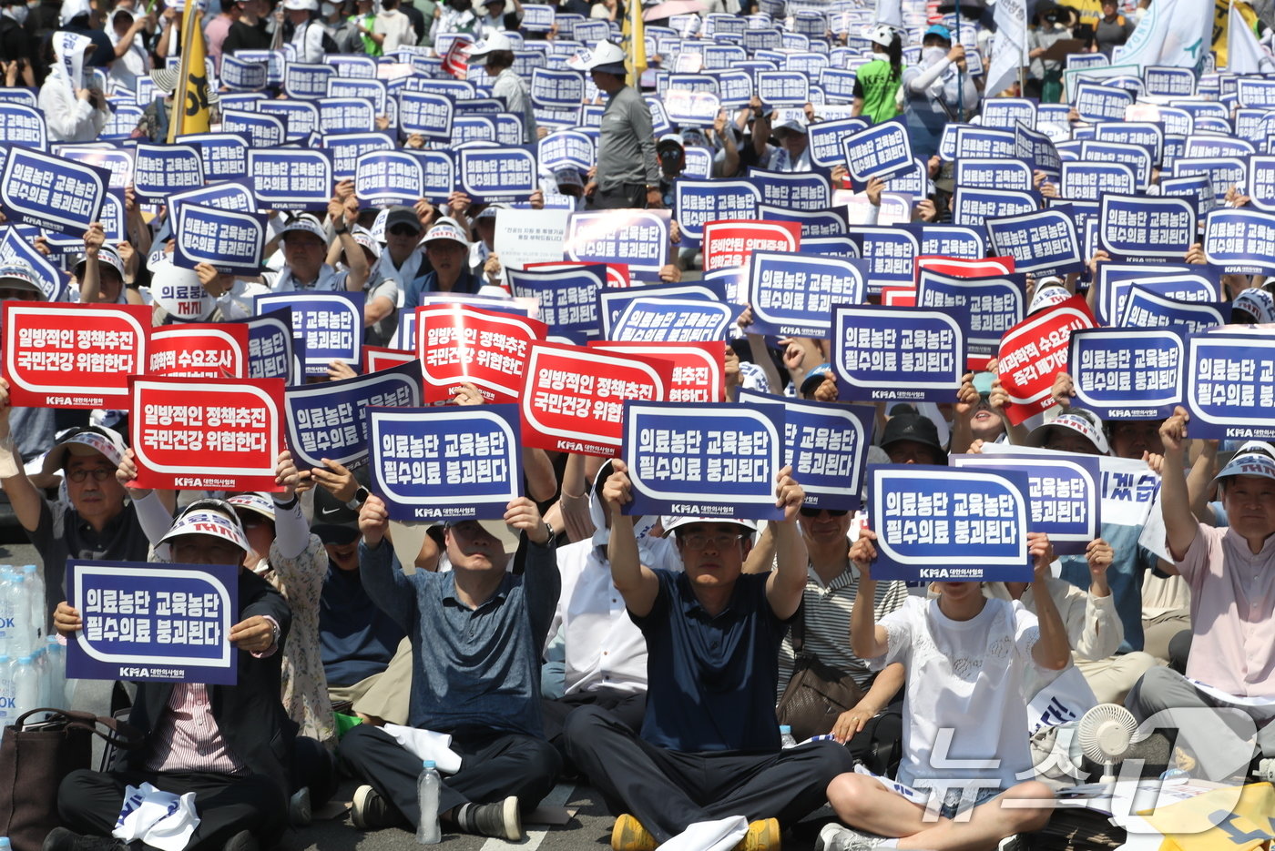 18일 서울 영등포구 여의도 환승센터 주변에서 열린 대한의사협회 전국 의사 총궐기대회에서 참석자들이 손팻말을 들고 정부에 &#39;의대 증원&#39; 철회를 촉구하고 있다. 2024.6.18/뉴스1 ⓒ News1 임세영 기자