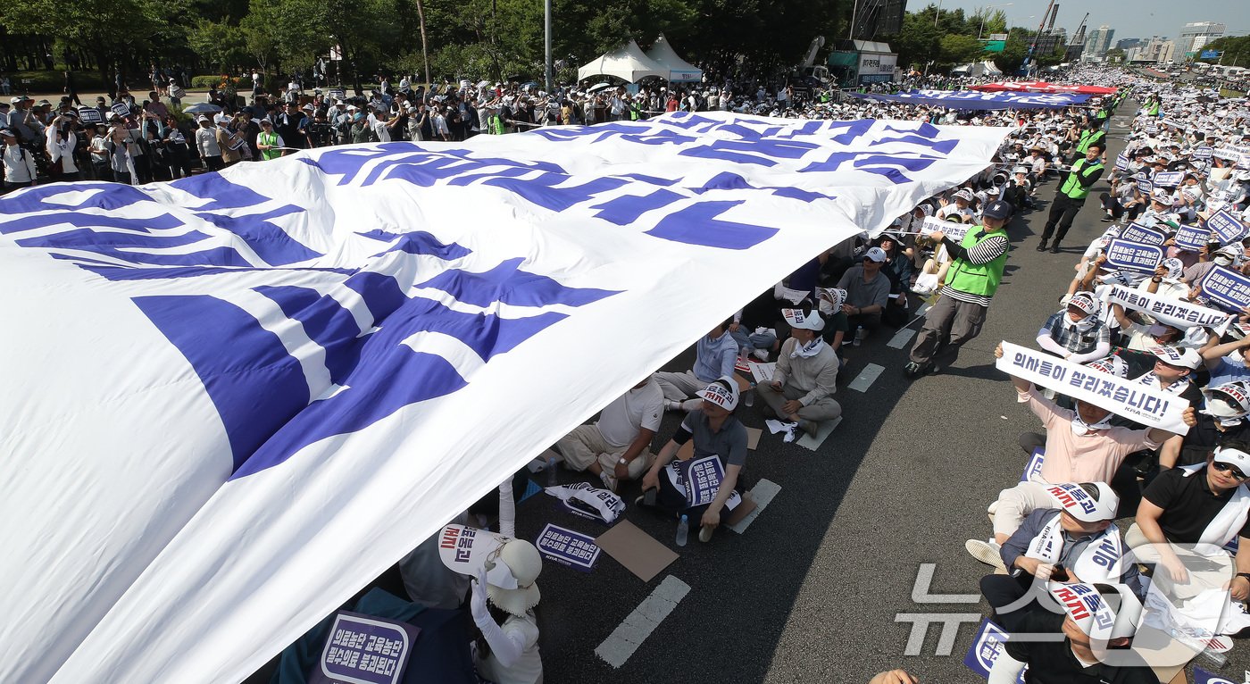 본문 이미지 - 18일 서울 영등포구 여의도 환승센터 주변에서 열린 대한의사협회 전국 의사 총궐기대회에서 참석자들이 대형 현수막 퍼포먼스를 펼치며 정부의 '의대 증원' 철회를 촉구하고 있다. 2024.6.18/뉴스1 ⓒ News1 임세영 기자