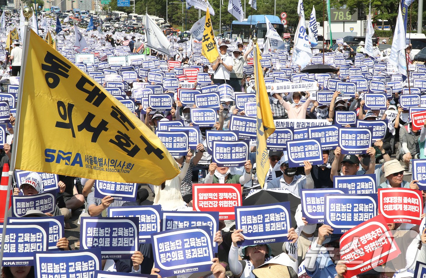 18일 서울 영등포구 여의도 환승센터 주변에서 열린 대한의사협회 전국 의사 총궐기대회에서 참석자들이 손팻말을 들고 정부의 &#39;의대 증원&#39; 철회를 촉구하고 있다. 2024.6.18/뉴스1 ⓒ News1 임세영 기자