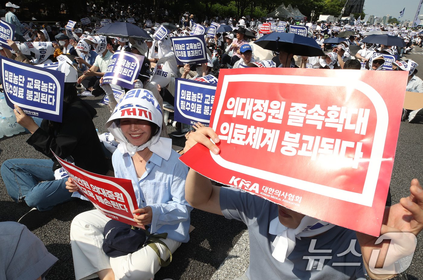 18일 서울 영등포구 여의도 환승센터 주변에서 열린 대한의사협회 전국 의사 총궐기대회에서 참석자들이 손팻말을 들고 정부의 &#39;의대 증원&#39; 철회를 촉구하고 있다. 2024.6.18/뉴스1 ⓒ News1 임세영 기자