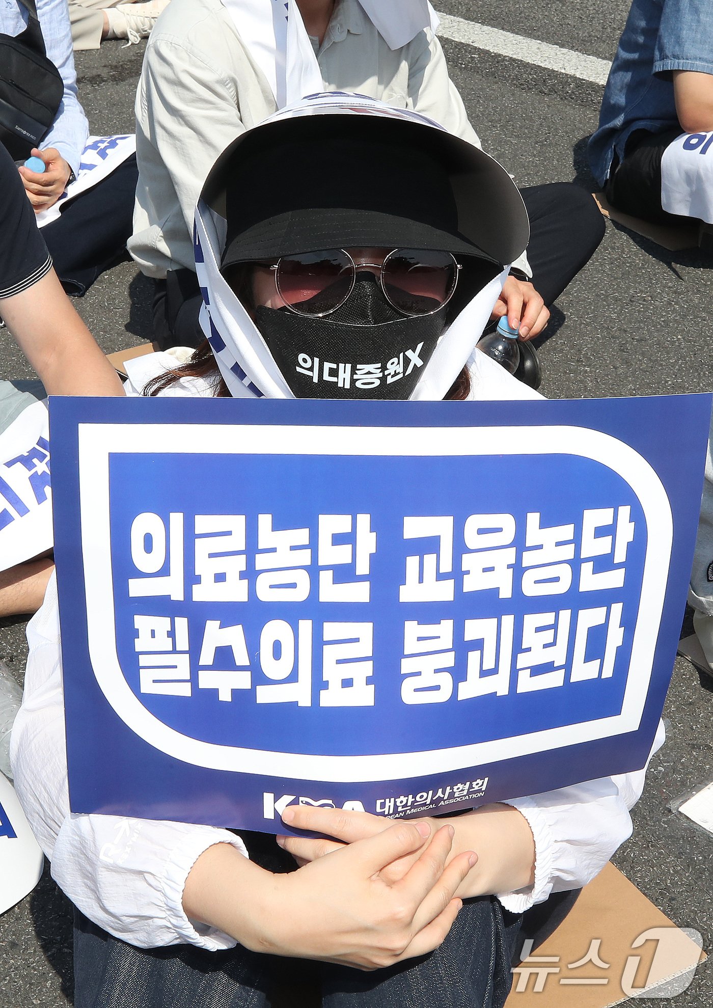 본문 이미지 - 18일 서울 영등포구 여의도 환승센터 주변에서 열린 대한의사협회 전국 의사 총궐기대회에서 한 참석자가 손팻말을 들고 정부의 '의대 증원' 철회를 촉구하고 있다. 2024.6.18/뉴스1 ⓒ News1 임세영 기자