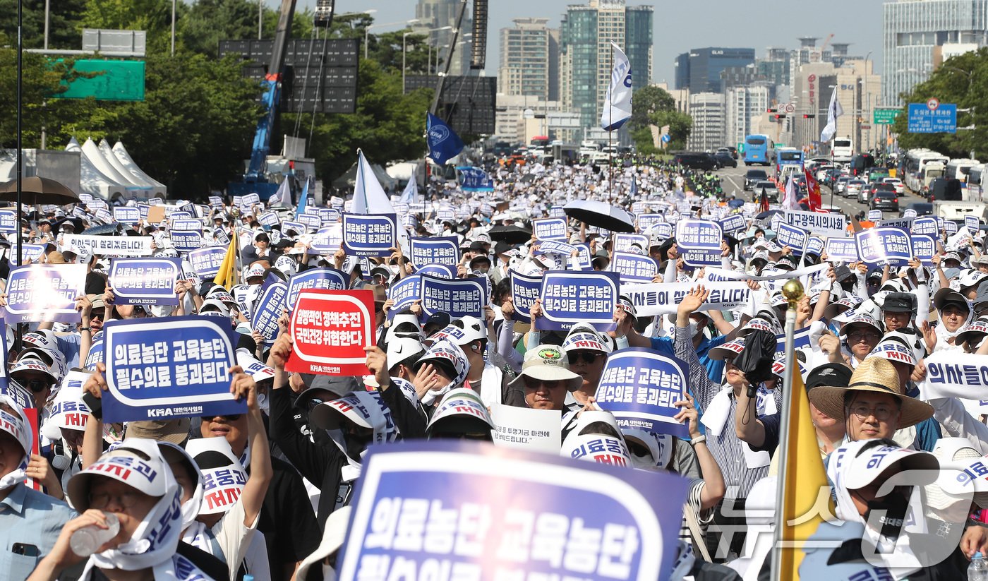 18일 서울 영등포구 여의도 환승센터 주변에서 열린 대한의사협회 전국 의사 총궐기대회에서 참석자들이 손팻말을 들고 정부의 &#39;의대 증원&#39; 철회를 촉구하고 있다. 2024.6.18/뉴스1 ⓒ News1 임세영 기자