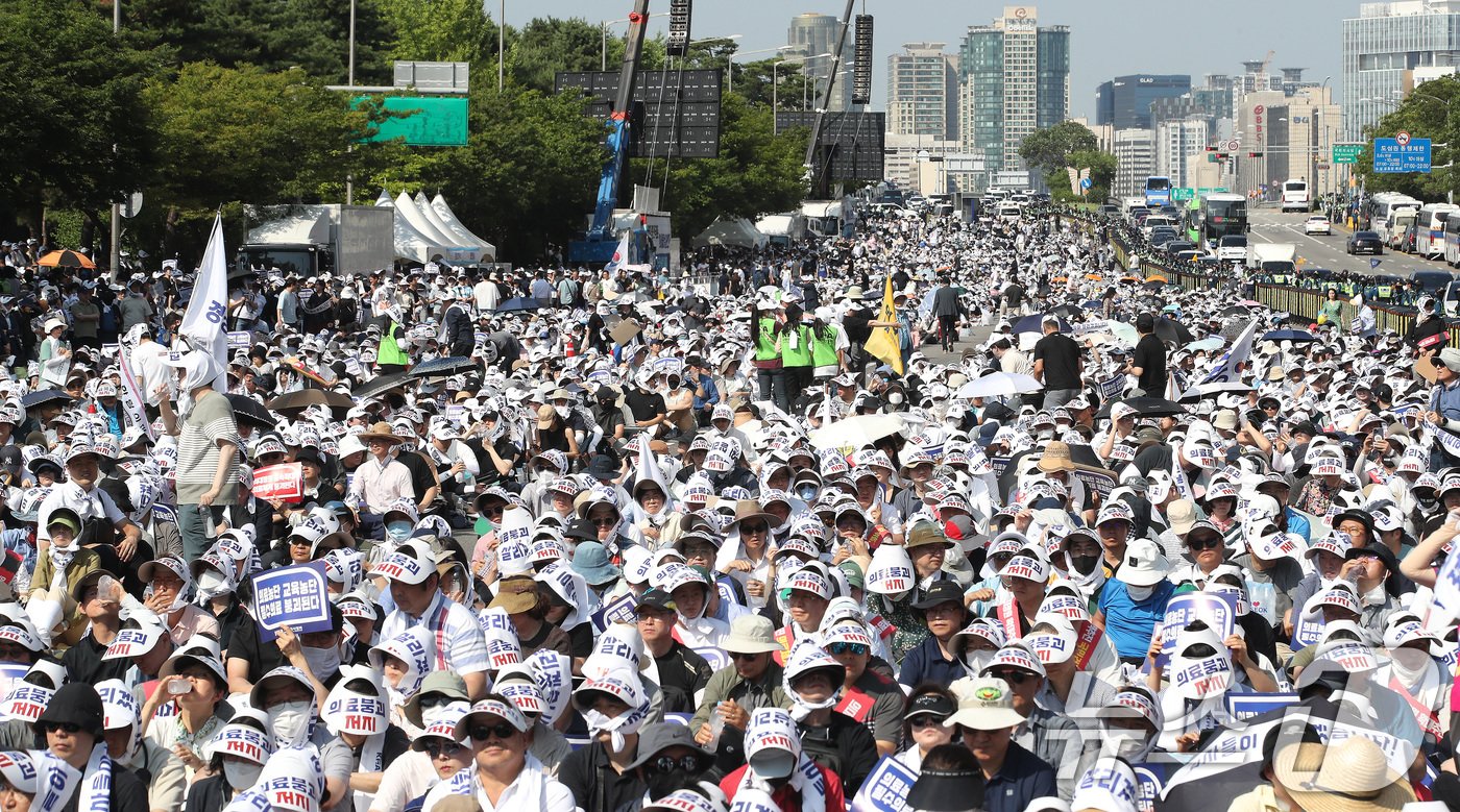 18일 서울 영등포구 여의도 환승센터 주변에서 열린 대한의사협회 전국 의사 총궐기대회에서 참석자들이 손팻말을 들고 정부의 &#39;의대 증원&#39; 철회를 촉구하고 있다. 2024.6.18/뉴스1 ⓒ News1 임세영 기자