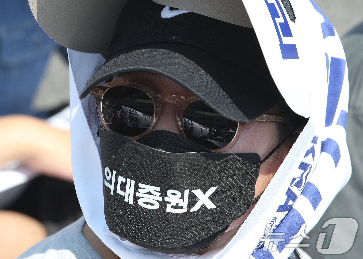 본문 이미지 - 18일 서울 영등포구 여의도 환승센터 주변에서 열린 대한의사협회 전국 의사 총궐기대회에서 한 참석자가 정부의 '의대 증원' 철회를 촉구하는 마스크를 쓰고 있다. 2024.6.18/뉴스1 ⓒ News1 임세영 기자