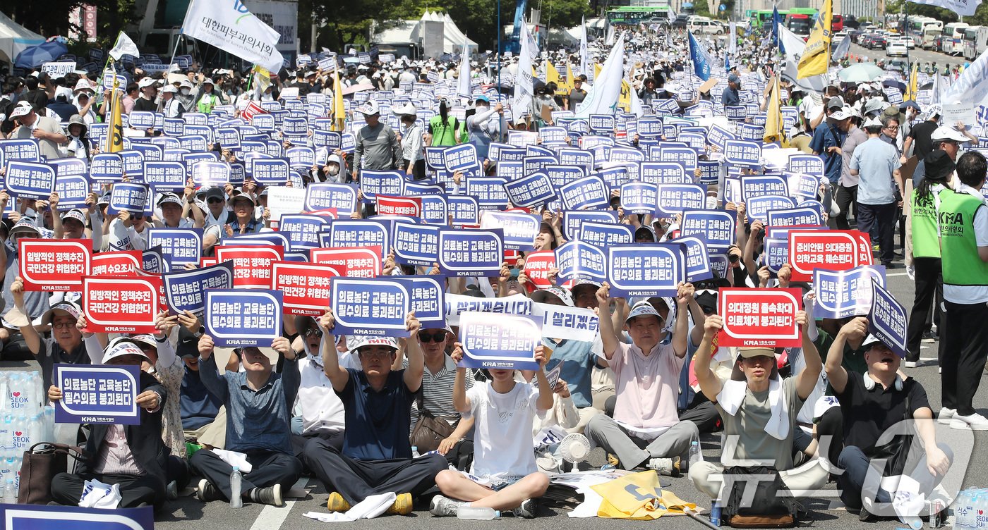 18일 서울 영등포구 여의도 환승센터 주변에서 열린 대한의사협회 전국 의사 총궐기대회에서 참석자들이 손팻말을 들고 정부에 &#39;의대 증원&#39; 철회를 촉구하고 있다. 2024.6.18/뉴스1 ⓒ News1 임세영 기자