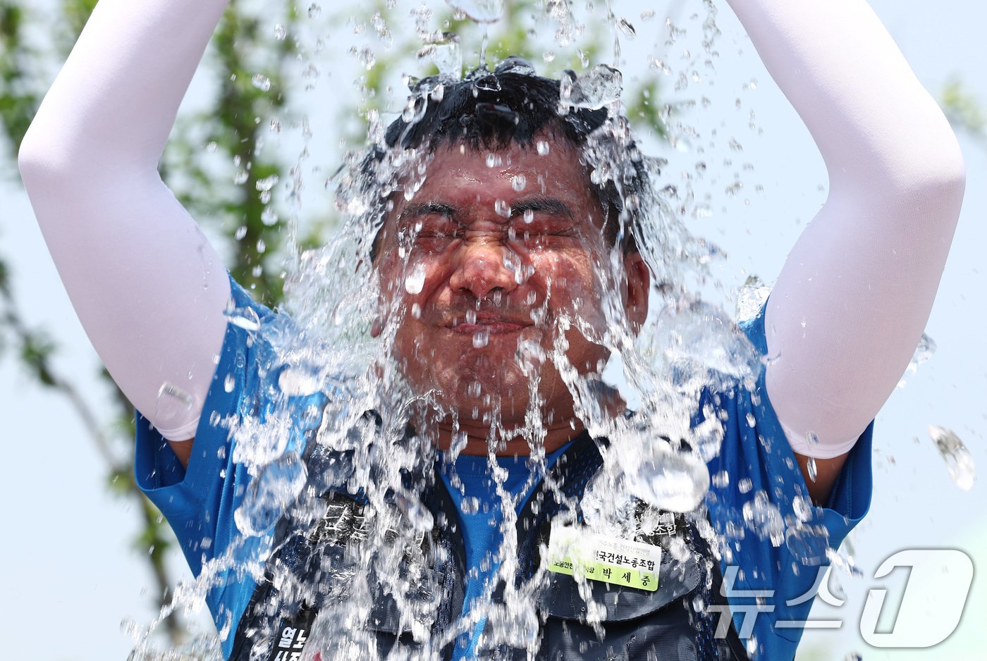 본문 이미지 - 민주노총 건설노조 조합원이 19일 오전 서울 여의도 국회 앞에서 열린 건설현장 편의시설 실태·폭염지침 법제화 촉구 기자회견에서 폭염법 제정을 촉구하는 아이스 챌린지를 하고 있다. 2024.6.19/뉴스1 ⓒ News1 김민지 기자