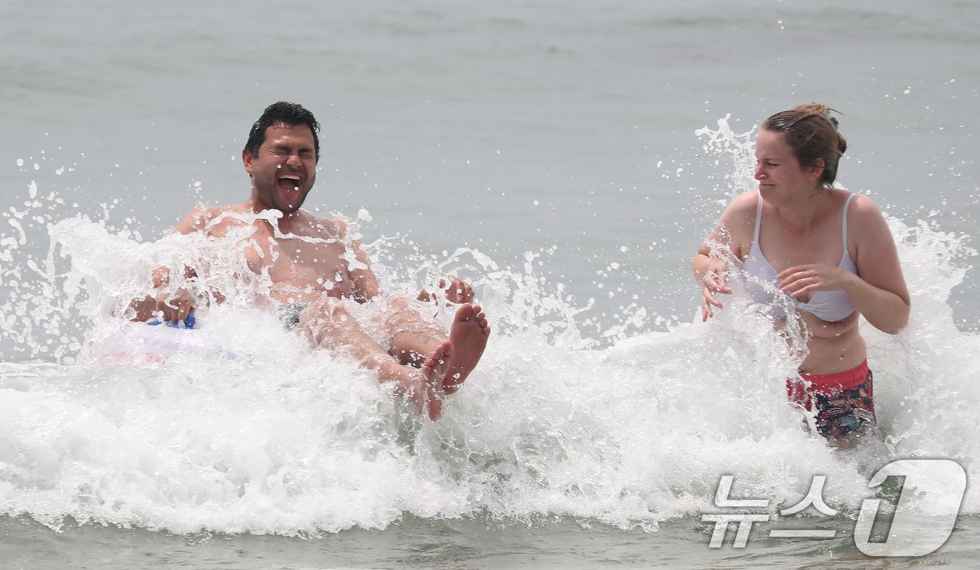 본문 이미지 - 부산지역에 이틀째 폭염주의보가 발효 중인 19일 부산 해운대해수욕장을 찾은 외국인 관광객들이 물놀이를 하며 더위를 식히고 있다. 2024.6.19/뉴스1 ⓒ News1 윤일지 기자