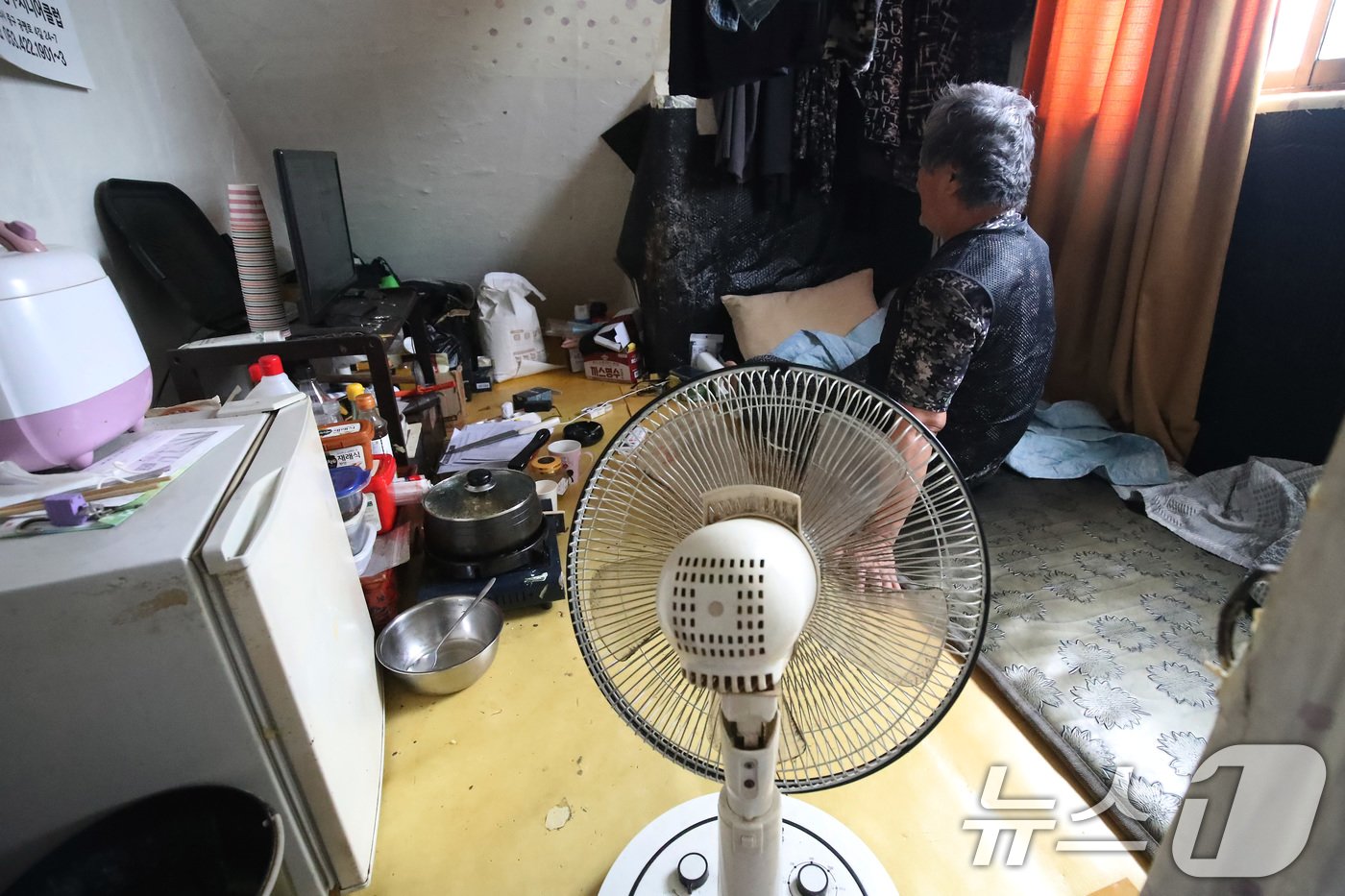 본문 이미지 - 불볕더위가 기승을 부리며 전국 대부분 지역에 폭염특보가 발효된 19일 대구의 한 쪽방촌에서 주민이 선풍기 하나에 의지해 앉아 있다. 2024.6.19/뉴스1 ⓒ News1 공정식 기자