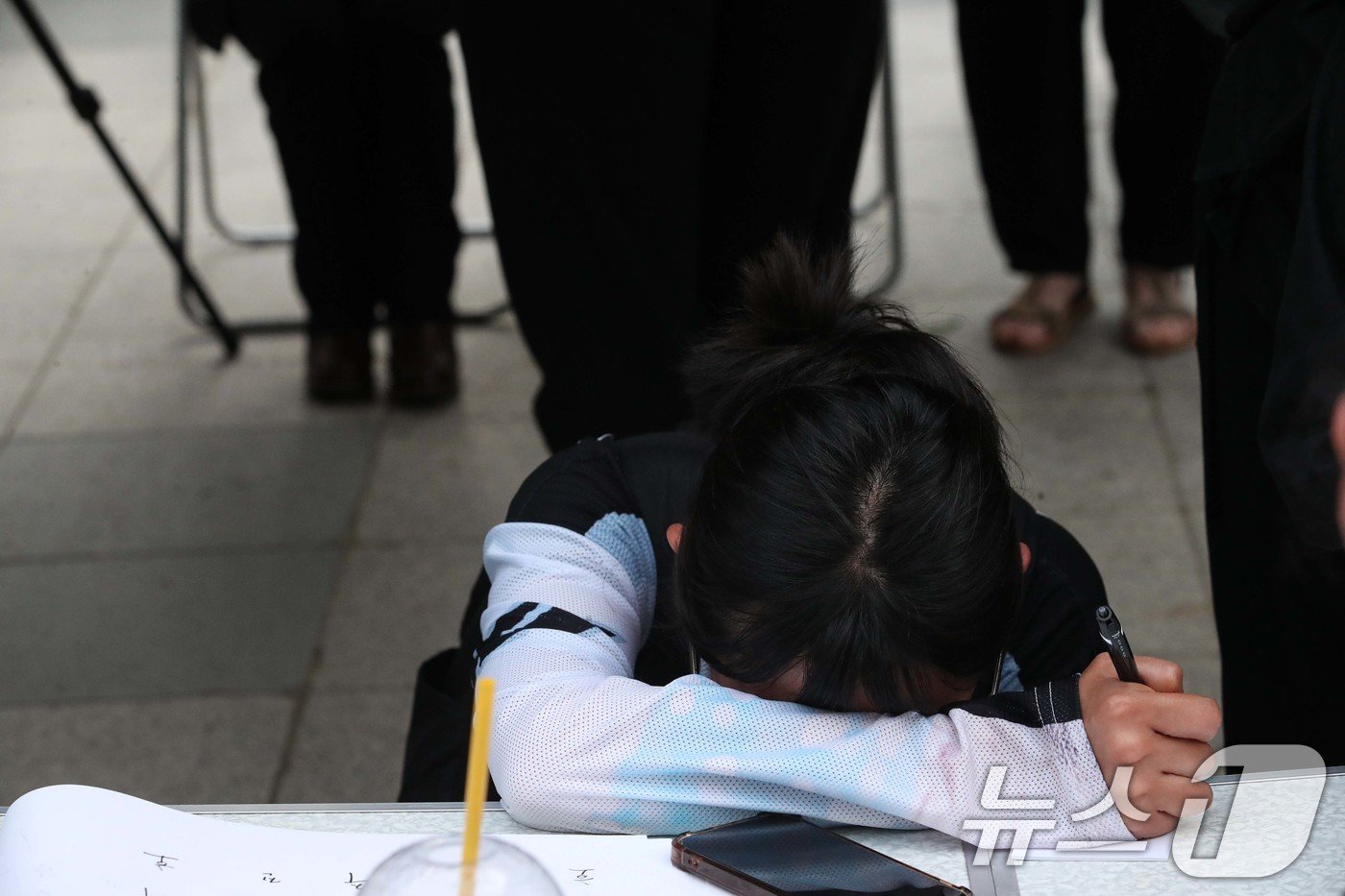 19일 오후 서울 용산구 용산역광장에 마련된 지난달 육군 신병교육대에서 군기훈련&#40;얼차려&#41;을 받다 숨진 훈련병의 시민 추모 분향소에서 헌화를 마친 한 추모객이 추모메시지를 작성하다 오열하고 있다. 2024.6.19/뉴스1 ⓒ News1 이승배 기자