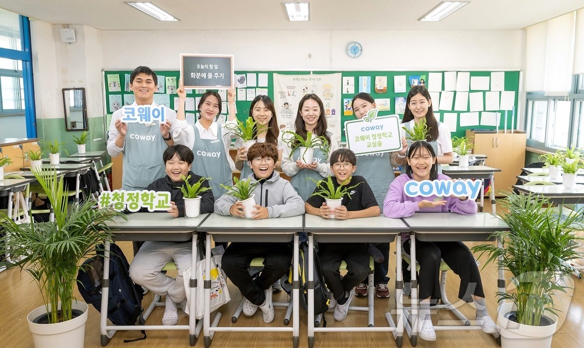 코웨이 임직원 봉사자들과 초등학생들이 &#39;청정학교 교실숲 제5호&#39; 조성을 기념해 단체 사진을 촬영하고 있다.&#40;코웨이 제공&#41;