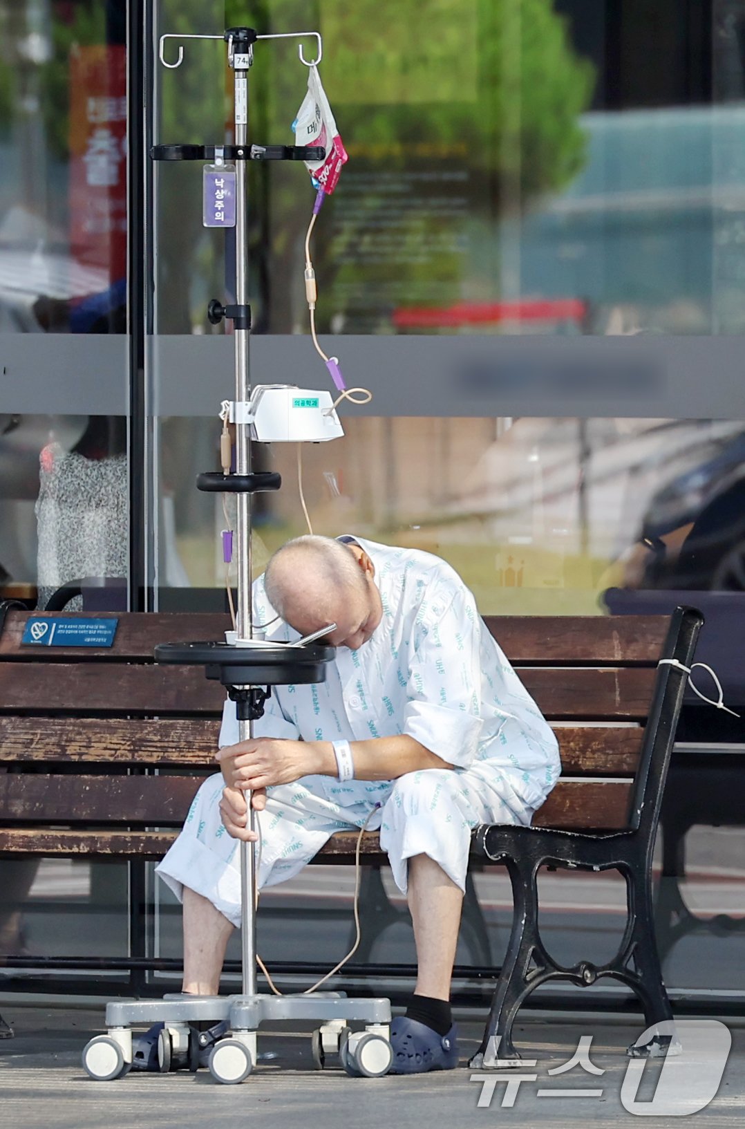 본문 이미지 - 주요 대형병원의 무기한 휴진 움직임이 확산하면서 의료 공백 우려가 커지고 있는 20일 서울의 한 대학병원에서 환자가 수액 걸이에 의지해 앉아있다. 2024.6.20/뉴스1 ⓒ News1 민경석 기자