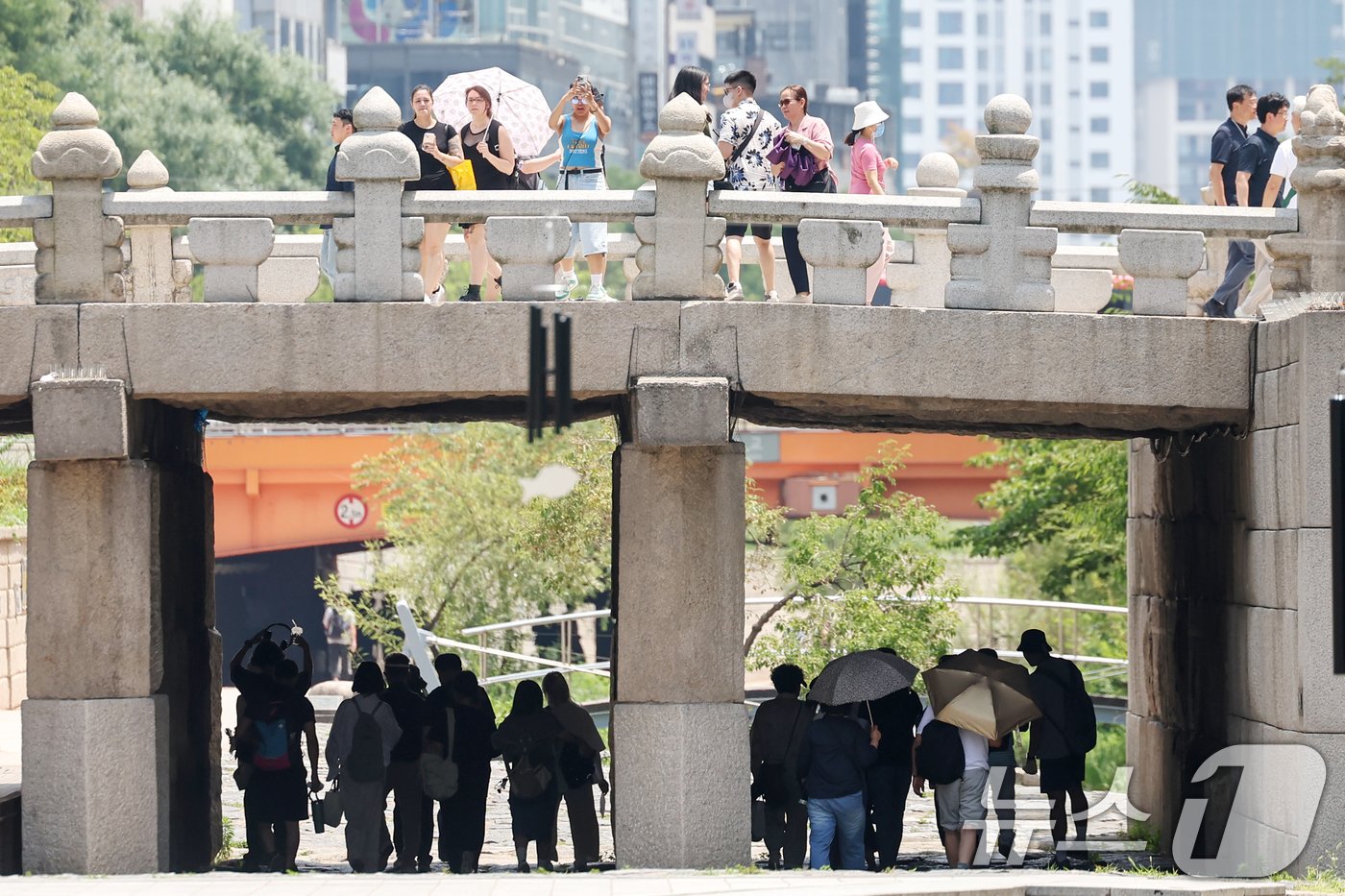 본문 이미지 - 서울 지역 낮 최고 기온이 35도까지 올라 불볕더위가 찾아온 20일 서울 종로구 청계천에서 시민들이 그늘 아래에서 따가운 햇빛을 피하고 있다. 2024.6.20/뉴스1 ⓒ News1 민경석 기자