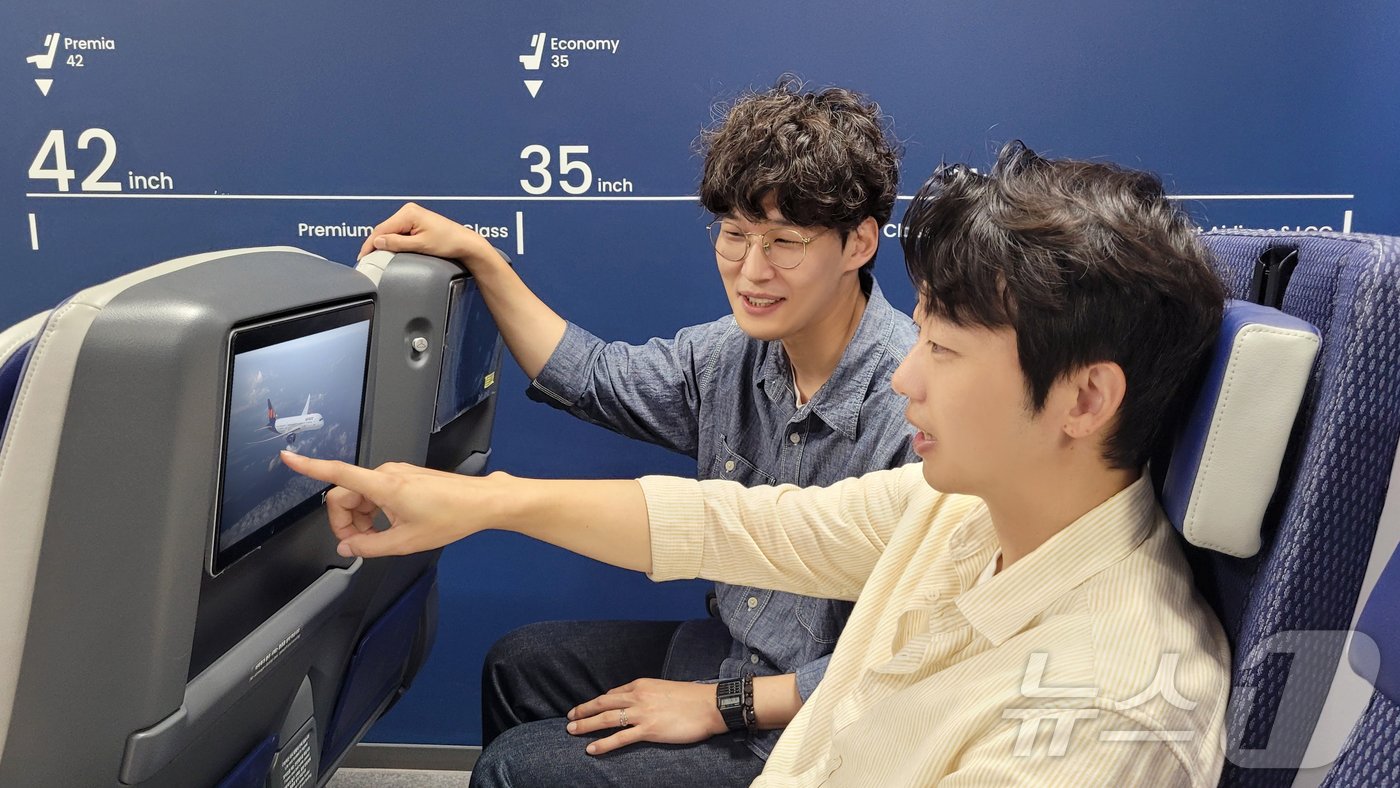 본문 이미지 - 이승민 에어프레미아 서비스기획개발 팀장과 한동경 매니저가 기내 엔터테인먼트를 시뮬레이션 하고 있다(에어프레미아 제공)