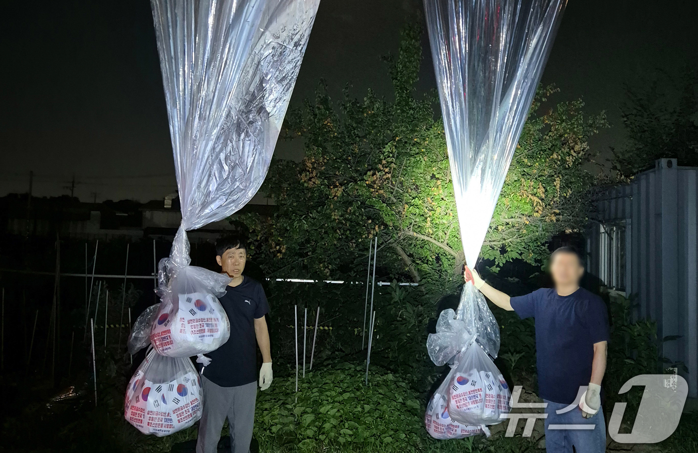 (서울=뉴스1) = 자유북한운동연합은 지난 20일 밤 경기도 파주에서 대북전단 30만장, 드라마와 트로트 등의 동영상을 저장한 USB 5천개, 1달러 지폐 3천장을 20개의 대형애 …