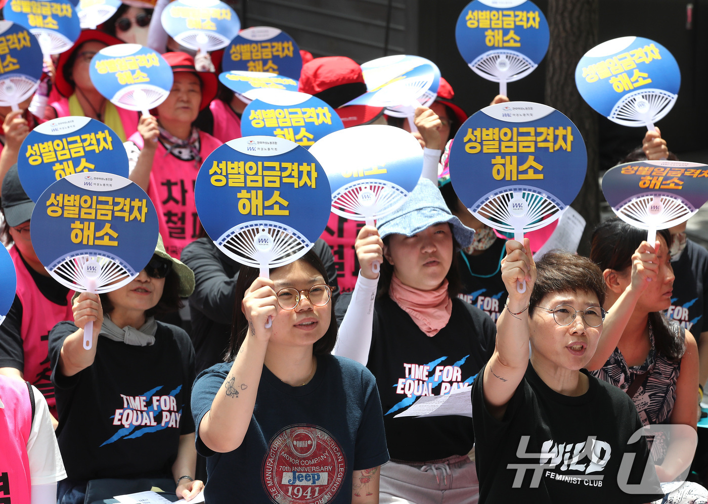 (서울=뉴스1) 임세영 기자 = 25일 서울 중구 삼일대로 서울지방고용노동청 앞에서 열린 최저임금 인상을 위한 전국여성노동자대회에서 참석자들이 '성별임금격차 해소'가 적힌 부채를 …