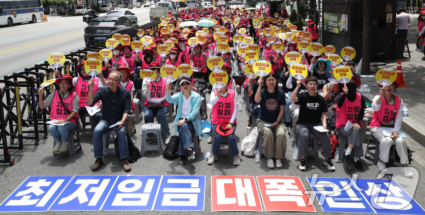 (서울=뉴스1) 임세영 기자 = 25일 서울 중구 삼일대로 서울지방고용노동청 앞에서 열린 최저임금 인상을 위한 전국여성노동자대회에서 참석자들이 '최저임금 인상'이 적힌 부채를 들고 …