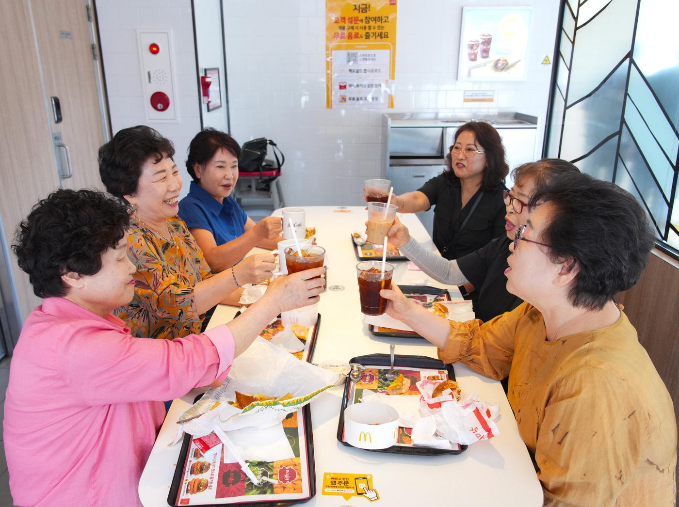본문 이미지 - 한국맥도날드가 국가평생교육진흥원과 함께 고령층 등 디지털 취약계층을 대상으로 키오스크 교육을 펼치고 있다. 사진은 실습 후 어르신들이 같이 식사를 즐기시는 모습.(한국맥도날드 제공)