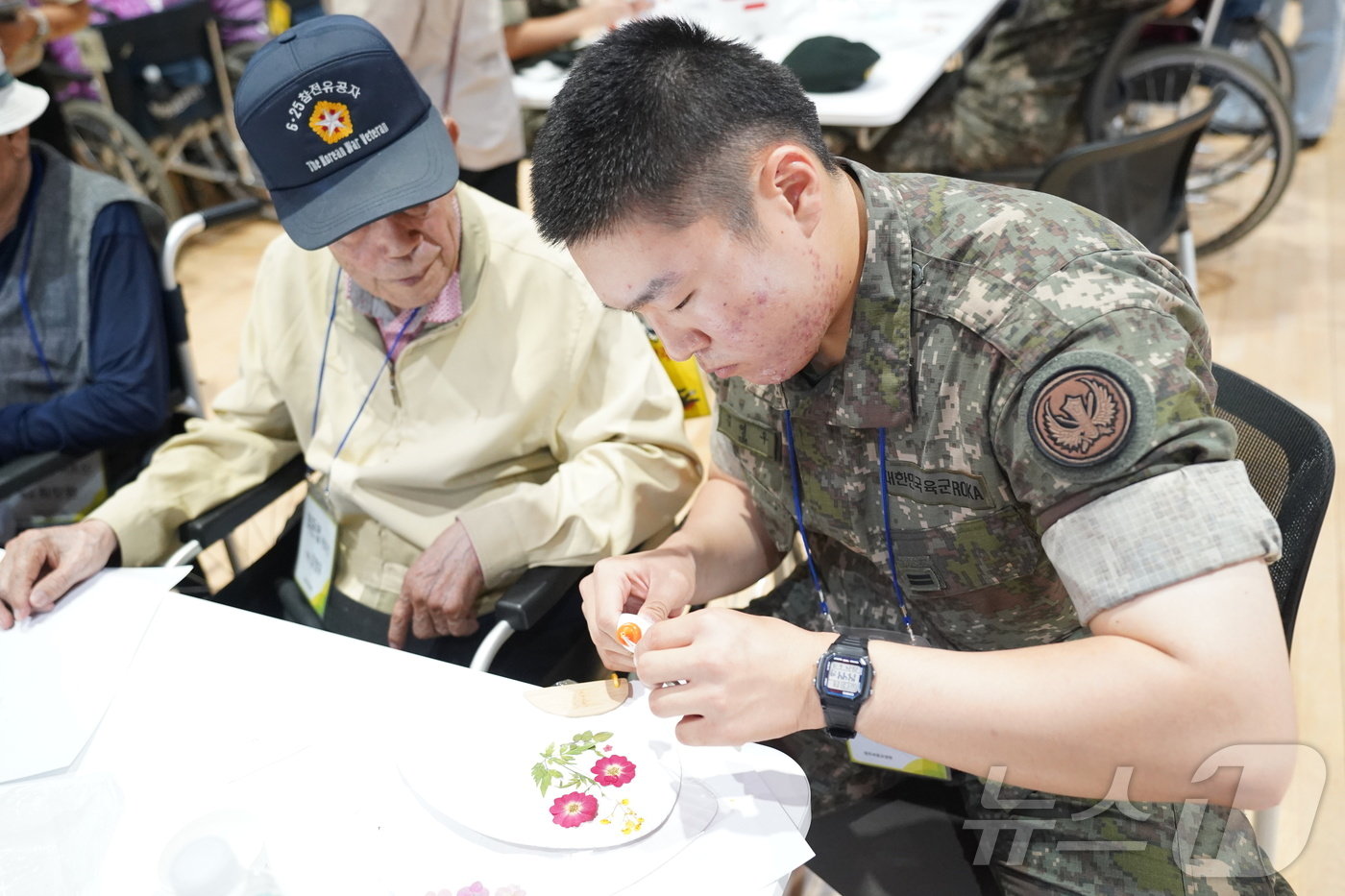 본문 이미지 - 한국보훈복지의료공단 산하 원주보훈요양원이 지난 19일 국립횡성숲체원에서 국가유공자를 비롯한 입소자들에게 항노화 산림치유프로그램을 제공한 가운데, 당시 한 입소자와 봉사에 나선 군 장병이 함께 프로그램에 참여하는 모습. (원주보훈요양원 제공) 2024.6.25/뉴스1