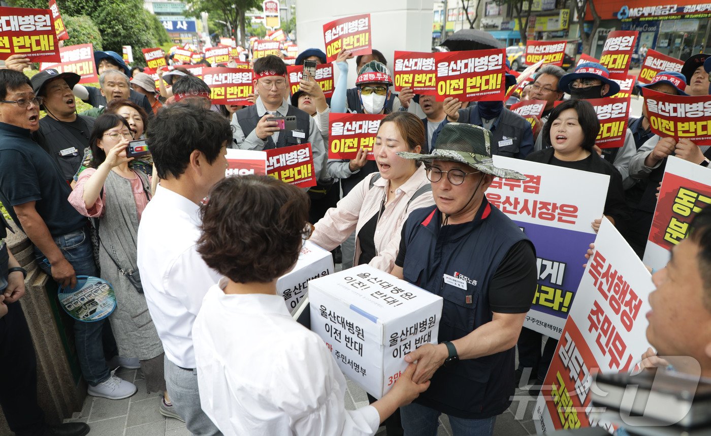 울산대병원 이전 반대 동구주민대책위원회 회원들이 26일 울산시청 남문 앞에서 울산대병원 이전 추진을 철회하라고 주장하며, 동구 주민 3만명이 참여한 서명을 울산시청 관계공무원에게 전달하고 있다.2024.6.26/뉴스1 ⓒ News1 김지혜 기자