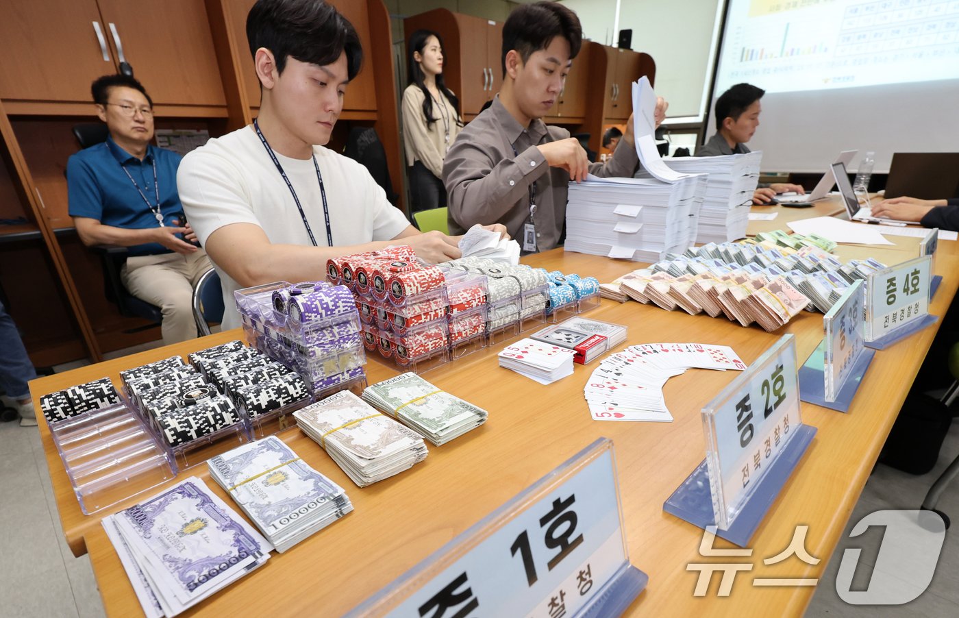 본문 이미지 - 전북경찰청 형사기동대 경찰들이 27일 전북자치도 전주시 전북경찰청에서 홀덤펍 업주 구속(도박, 환전, 장개설) 사건 관련 브리핑에 앞서 증거자료를 정리하고 있다. 2024.6.27/뉴스1 ⓒ News1 유경석 기자