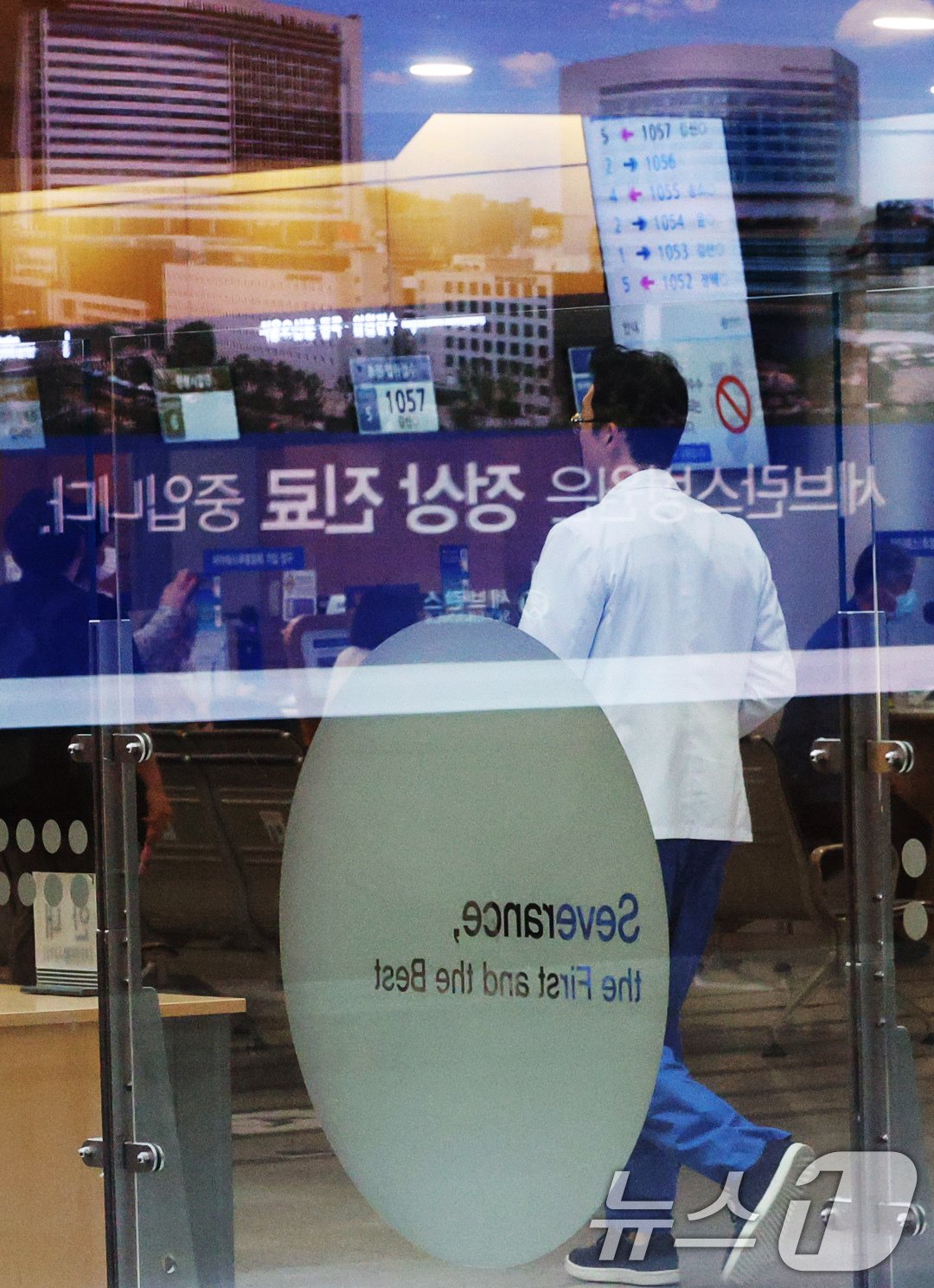 본문 이미지 - 연세 세브란스 교수들이 무기한 휴진에 돌입한 27일 오전 서울 서대문구 세브란스 병원 전광판에 표시 중인 '세브란스병원은 정상 진료 중입니다'안내 문구 앞으로 의료진이 지나가고 있다. 2024.6.27/뉴스1 ⓒ News1 장수영 기자