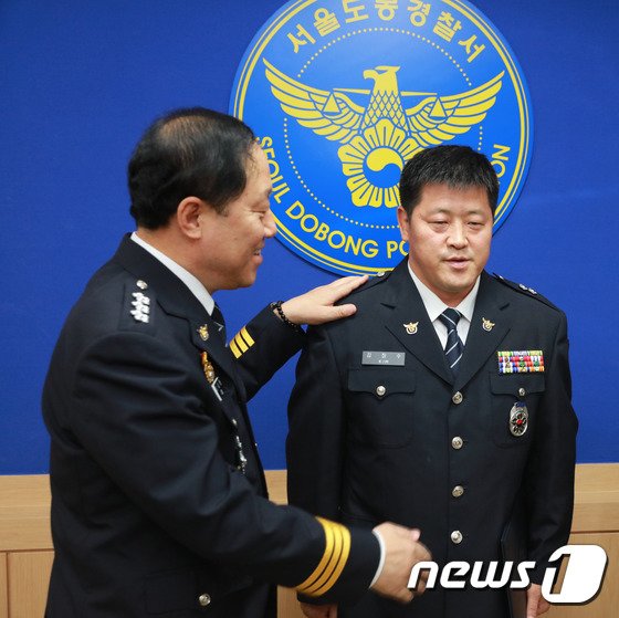 본문 이미지 - 2016년 6월 30일 서울 도봉경찰서에서 여중생 집단 성폭행 사건 가해자 22명을 검거한 김장수 당시 경위(오른쪽)에게 이상원 당시 서울경찰청장이 1계급 특진 계급장을 달아주고 있다. (서울지방경찰청 제공) ⓒ News1